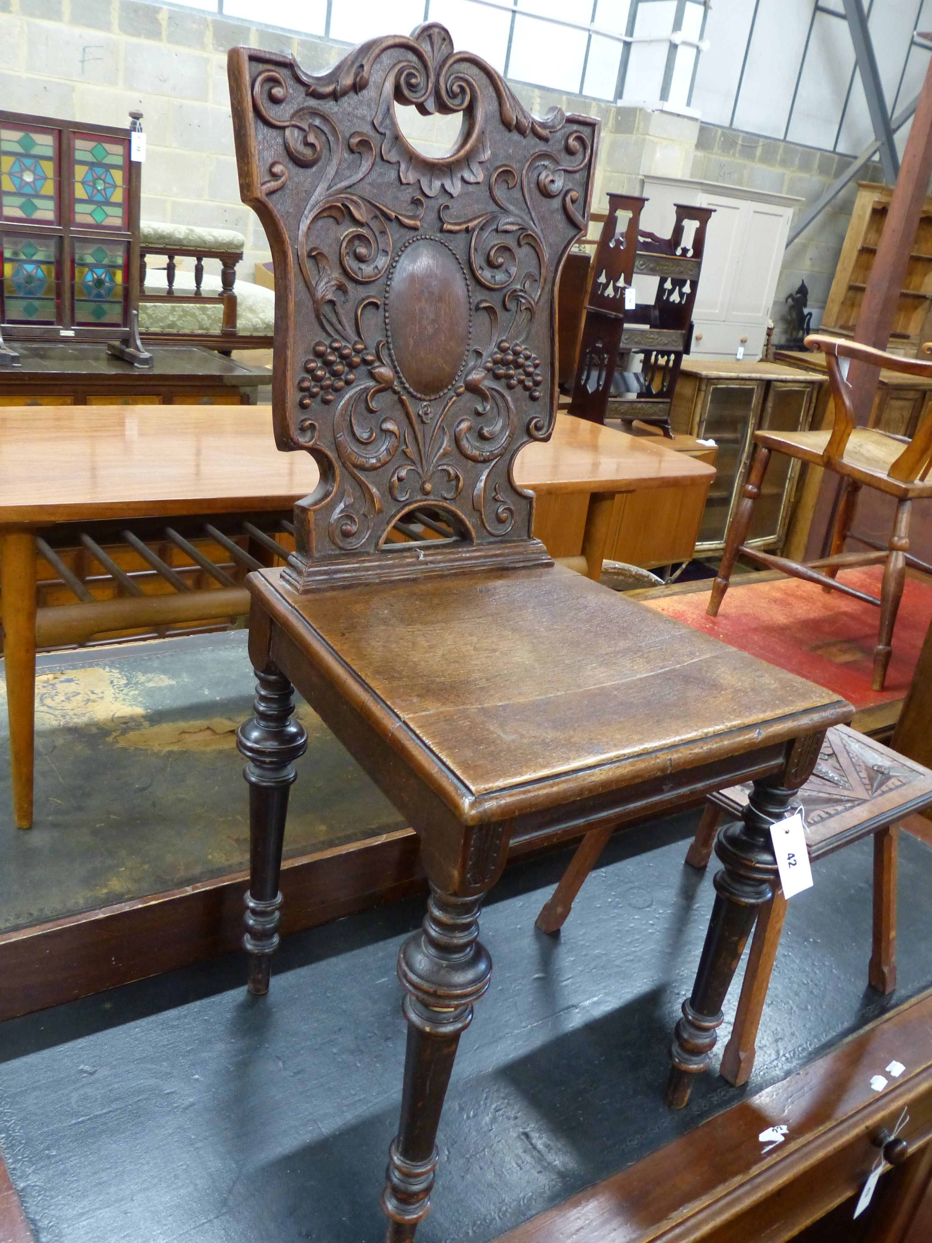 A late Victorian carved oak hall chair and a small occasional table